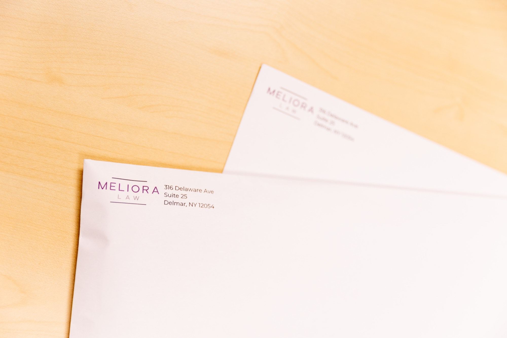 Meliora Law letterhead and an envelope on the desk