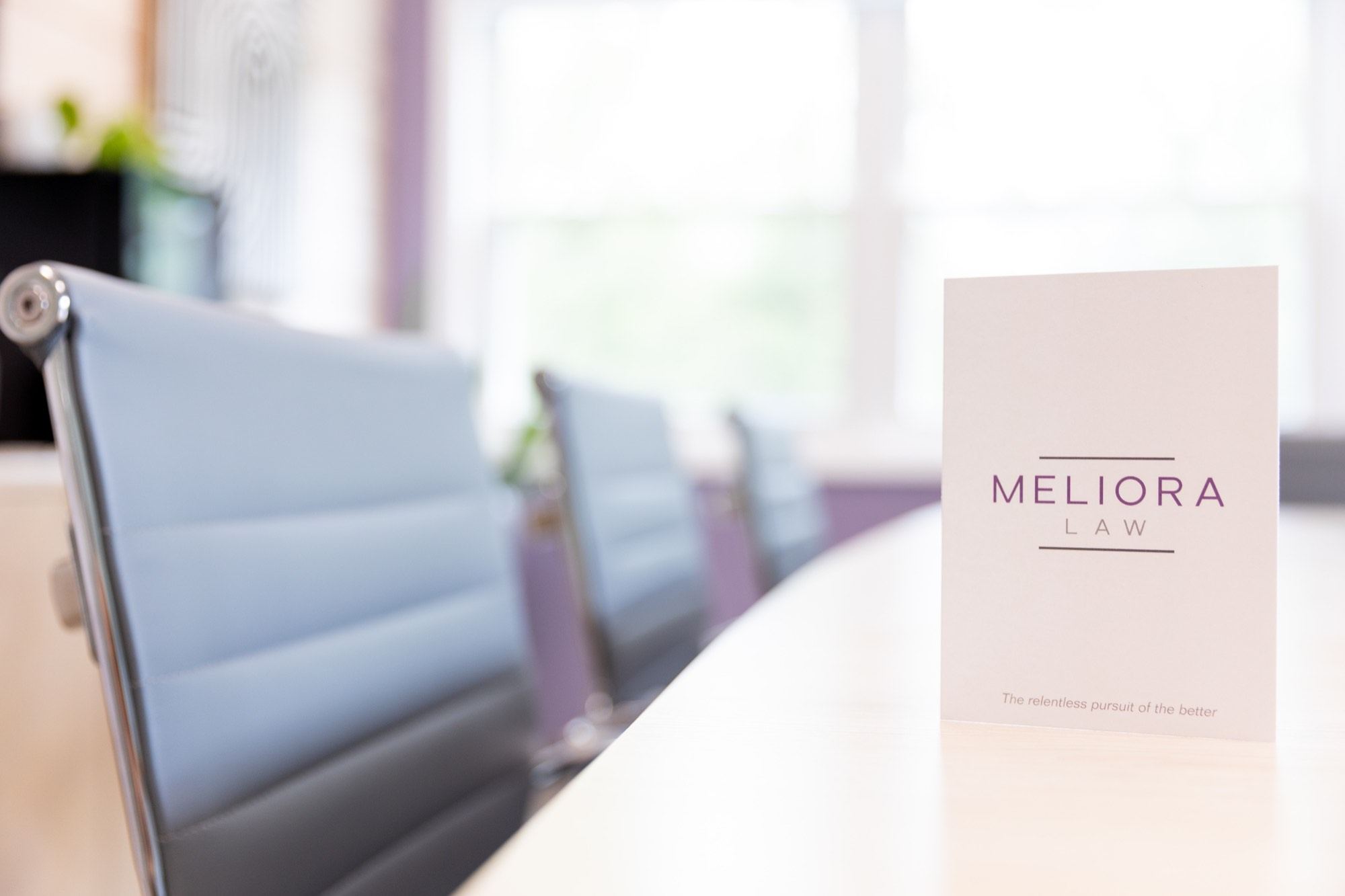 A Meliora Law brochure standing on the conference table