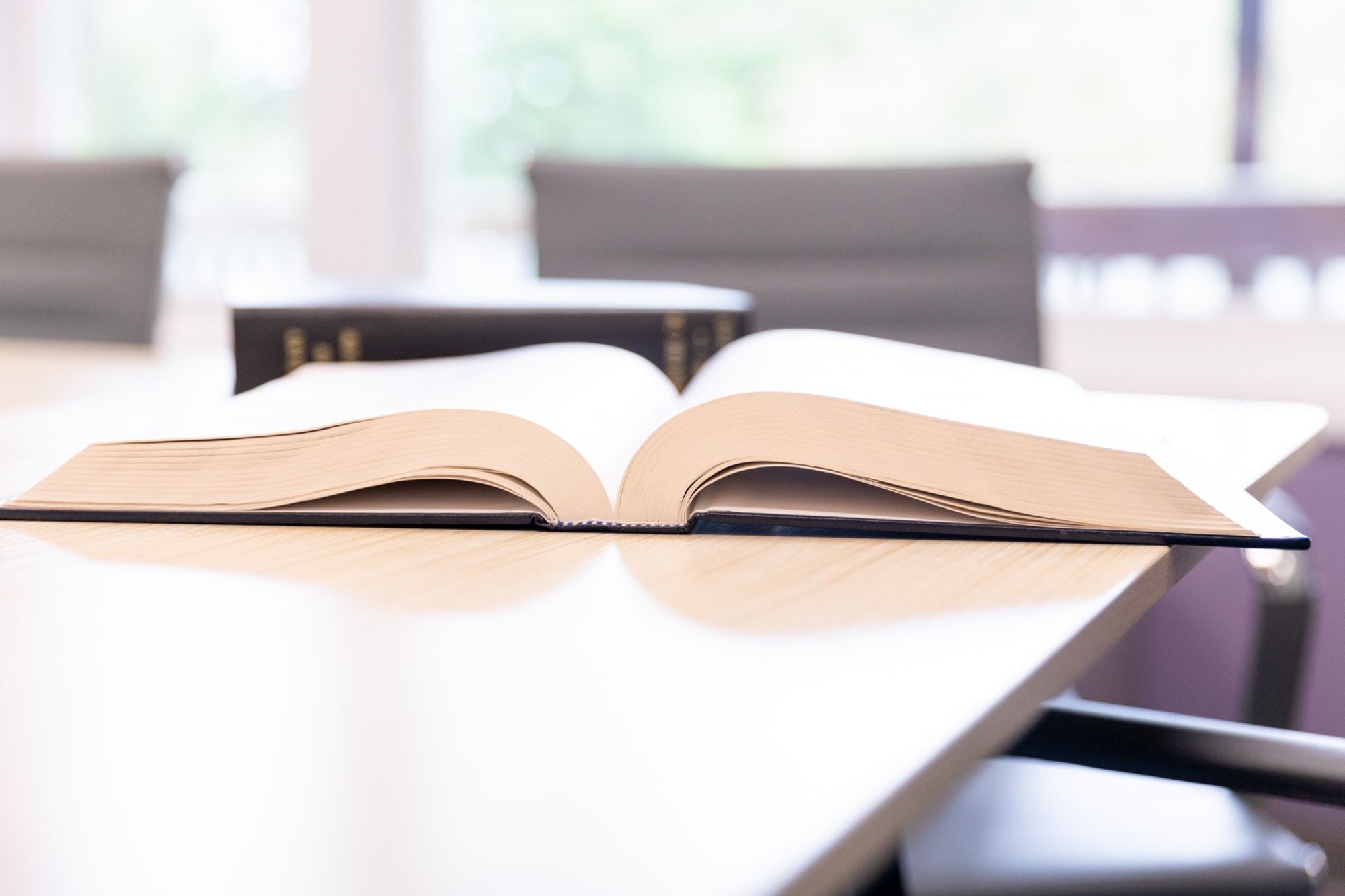 An open legal reference volume on the conference table