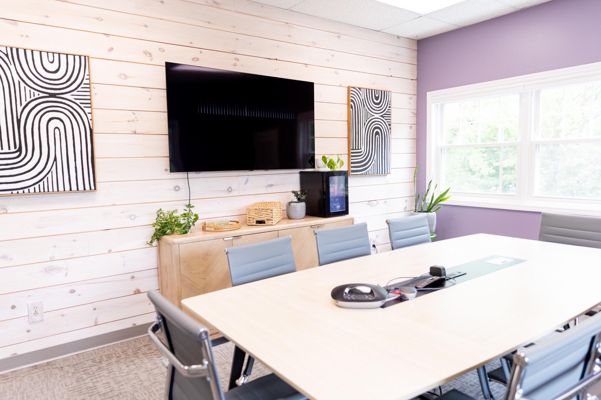 The Meliora Law conference room, table set under the wall-mounted screen